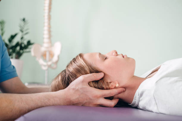A woman lies with her head supported during a body-oriented coaching session, symbolizing stress release, grounding, and emotional support for expat women.