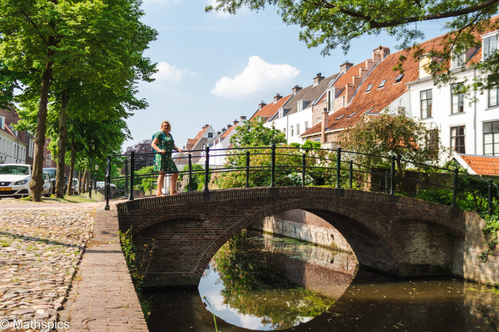 Cat Boersma standing on a bridge in Amersfoort, symbolizing connection, transition, and guidance for expat women navigating change through nature therapy.