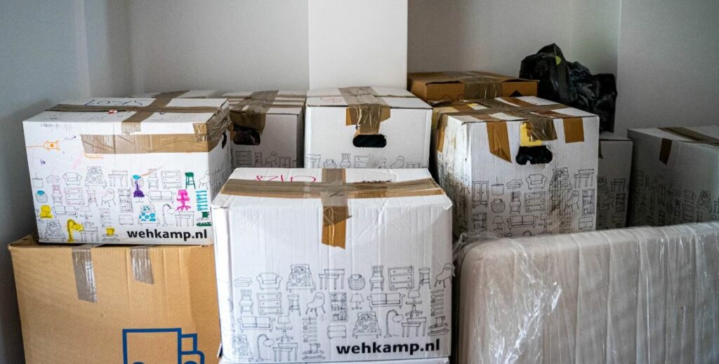 Stacked moving boxes in a new home, reflecting the challenges and emotional weight of relocation for expat women seeking stability.