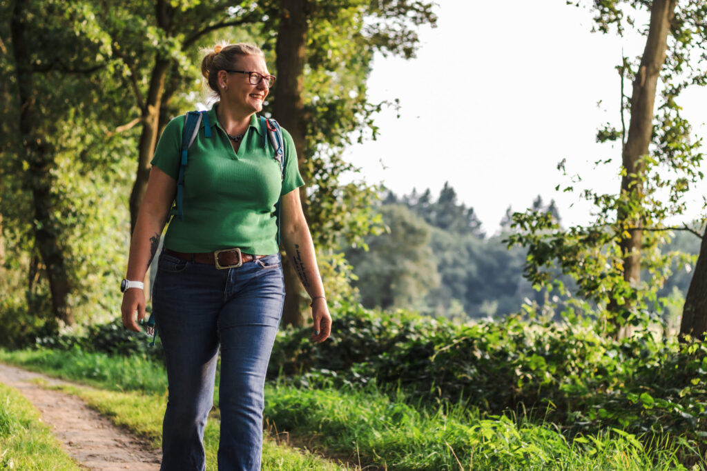 Cat Boersma walking through a green forest path, symbolizing the need for expat women to reconnect with themselves and find strength in nature